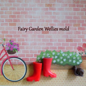 Könnte beinhalten: Eine dekorative Szene mit einem roten Fahrrad, einem Paar roter Gummistiefel und einer Schneckenfigur. Der Hintergrund zeigt eine Backsteinmauer und den Text "Fairy Garden Wellies mold".