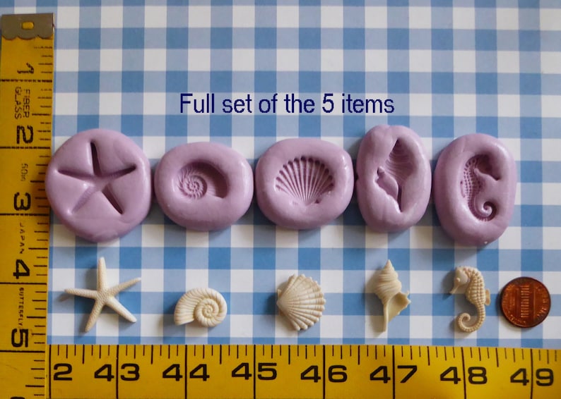 K&ouml;nnte beinhalten: Eine Sammlung von f&uuml;nf lavendelfarbenen Formen in verschiedenen Muschelformen, darunter ein Seestern, eine Spiralschale, eine Jakobsmuschel, eine Muschel und ein Seepferdchen. Darunter passende Muschelminiaturen. Der Text "Full set of the 5 items" ist sichtbar.