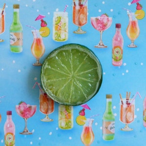 May include: A colourful illustration showing a lime slice surrounded by images of cocktails in glasses and bottles. The drinks have straws and decorations. The background is light blue with white dots, evoking a summery theme.
