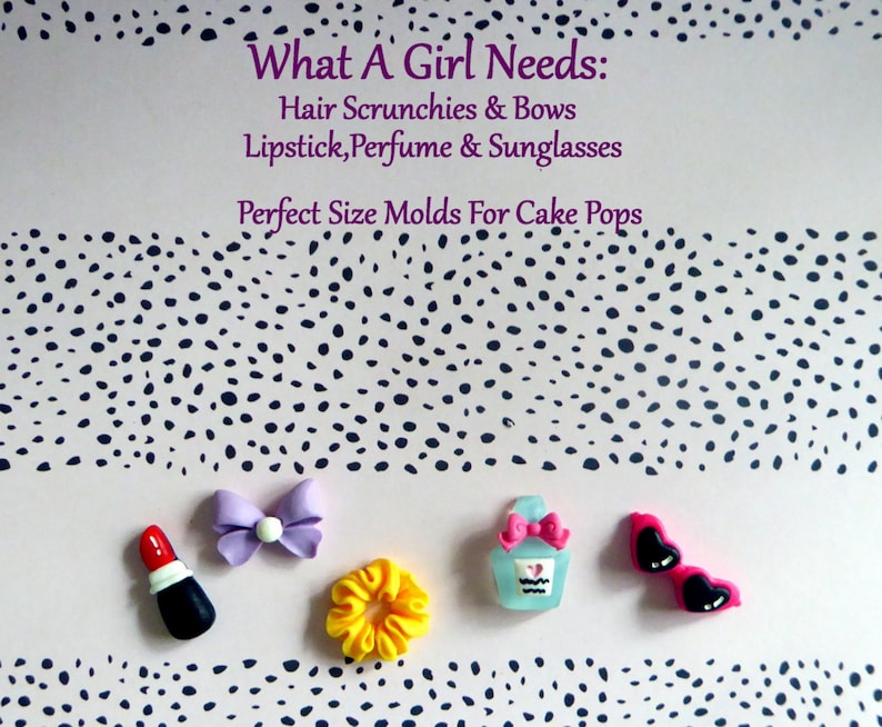 May include: An assortment of miniature accessories including a red lipstick, a purple bow, a yellow scrunchie, a perfume bottle, and pink heart-shaped sunglasses. The text "What A Girl Needs" is displayed above the accessories.