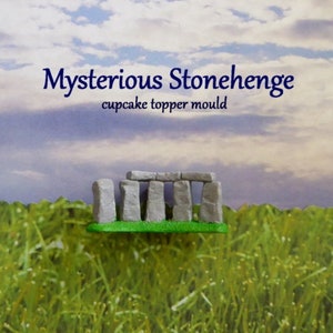 May include: A miniature Stonehenge cupcake topper mold. The mold is gray and green, with the text "Mysterious Stonehenge" and "cupcake topper mould" in blue. The background features a grassy field and a cloudy sky.