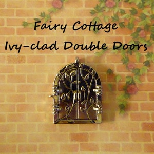 May include: A miniature metal double door with an arched top, featuring a leaf design, is mounted on a brick wall. The text "Fairy Cottage Ivy-clad Double Doors" is above the door. Decorative vines with flowers are in the background.