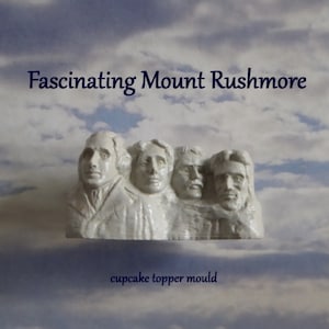 May include: A white Mount Rushmore cupcake topper mould against a cloudy blue sky background. The text "Fascinating Mount Rushmore" is above the topper, and "cupcake topper mould" is below.