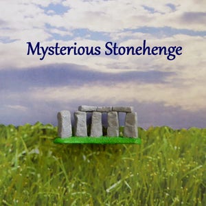 May include: A miniature model of Stonehenge, featuring gray stone structures on a green base, set against a backdrop of a grassy field and a cloudy sky. The text "Mysterious Stonehenge" is displayed above the model.