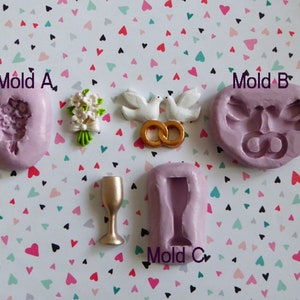 May include: A collection of wedding-themed molds and decorations. Includes a bouquet, doves with gold rings, and a champagne glass. The molds are lavender, and the decorations are white, green, and gold. The text "Mold A", "Mold B", and "Mold C" is visible.