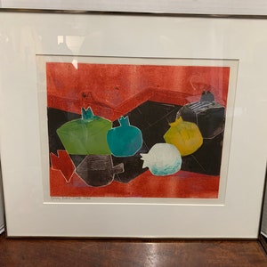Könnte beinhalten: Ein gerahmter Druck eines farbenfrohen abstrakten Stilllebens mit geometrischen Formen und rotem Hintergrund. Der Druck ist mit "Granatapfel Stillleben 1968" betitelt.