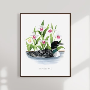May include: A watercolor painting of a loon swimming in a lake with white and pink lady slipper orchids in the background. The painting is framed and has the word "MINNESOTA" written at the bottom.