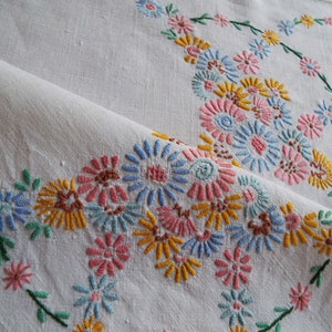 Vintage quadratische Tischdecke mit rosa, gelben und blauen Gänseblümchen. Handbestickte weiße Leinentischdecke. Tischwäsche zum Teekränzchen