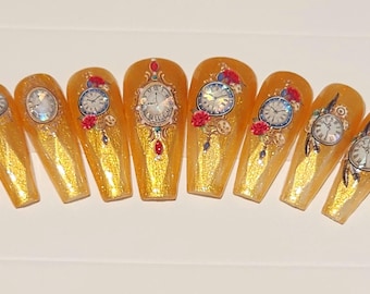 May include: Set of ten gold glitter false nails with clock and floral designs.