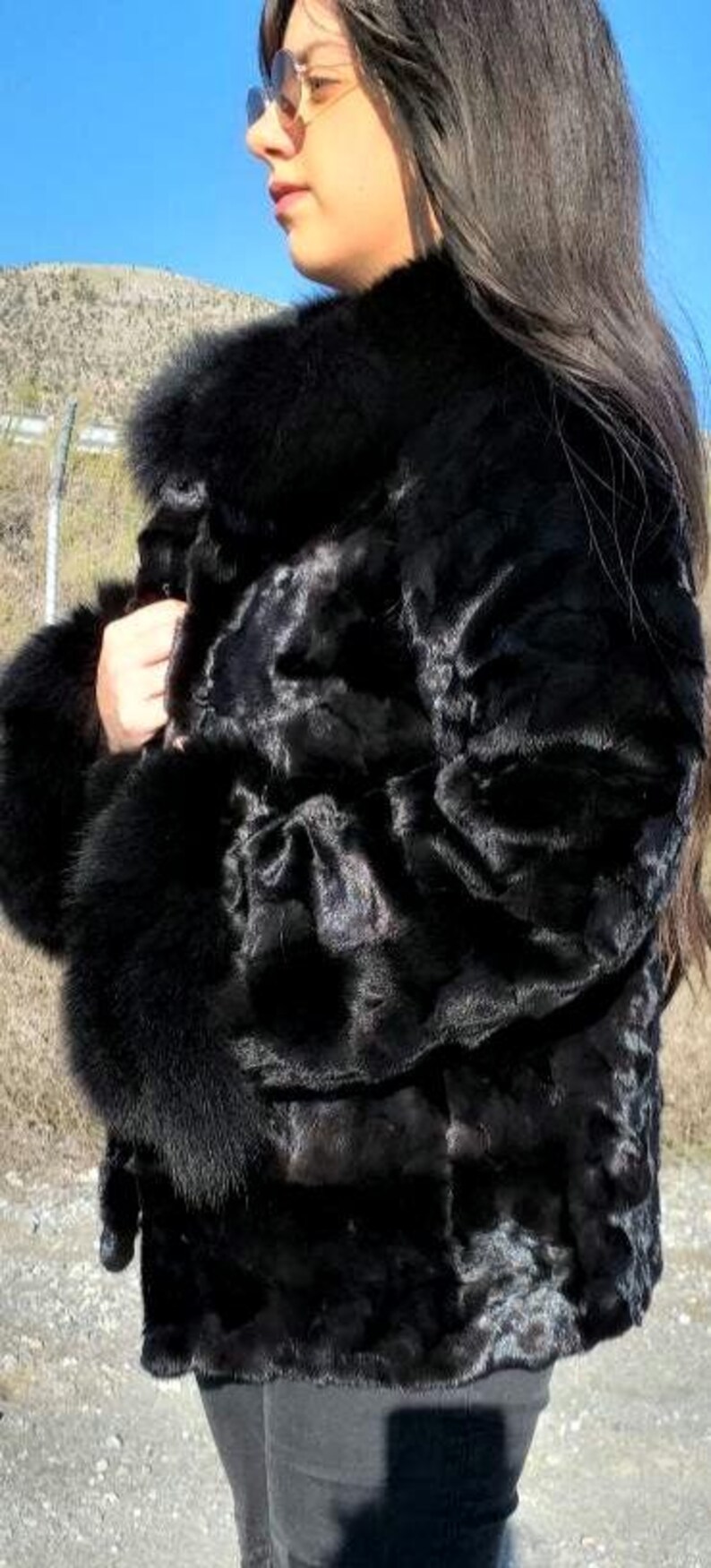 May include: A black fur coat with a large collar and cuffs. The coat is made of a soft, luxurious fur and has a classic, elegant style.