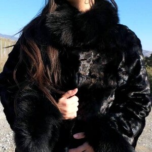 May include: A black fur coat with a large collar and cuffs. The coat is made of a soft, luxurious fur and has a sleek, modern design.