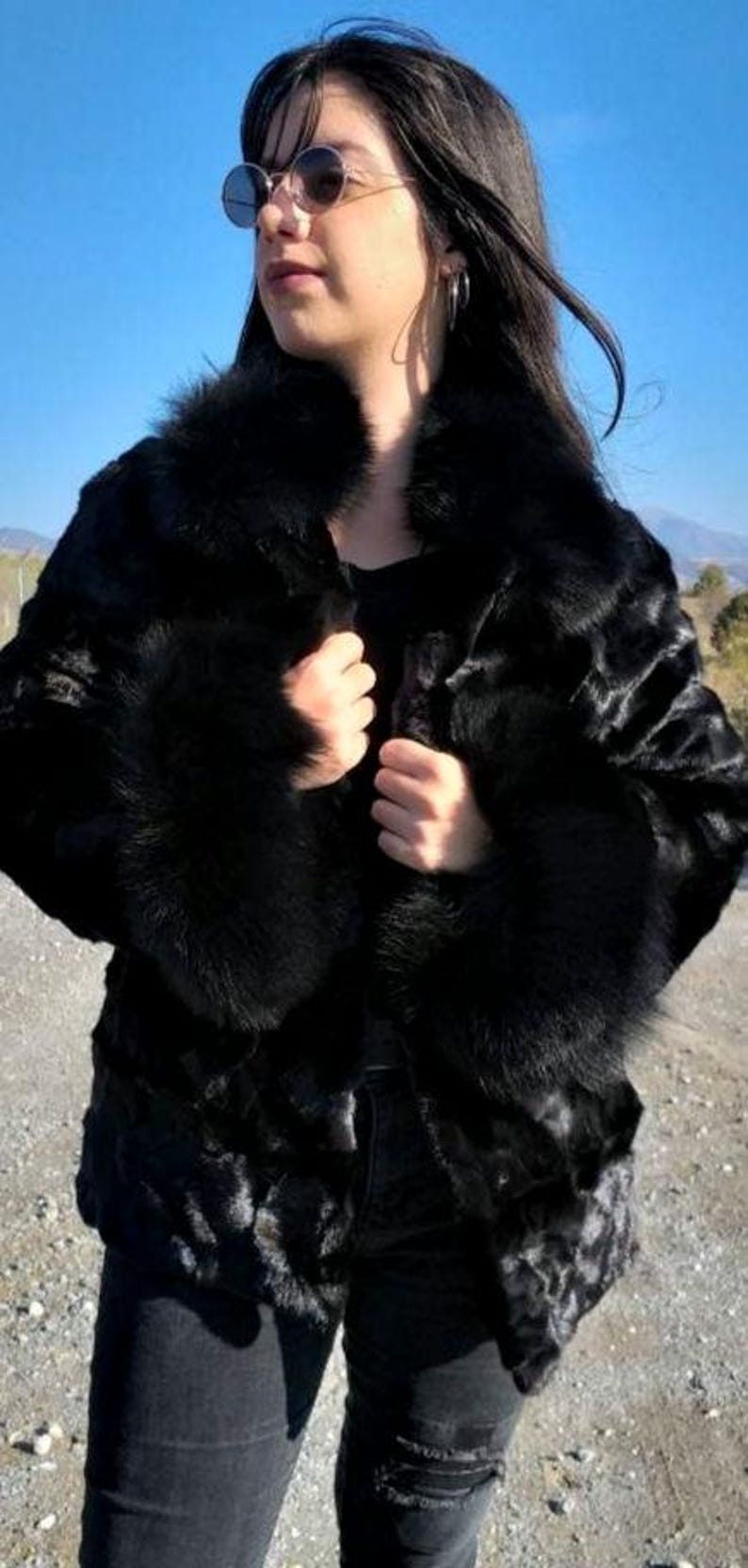 May include: A black fur coat with a large collar and cuffs. The coat is made of a soft, luxurious fur and has a sleek, modern design.
