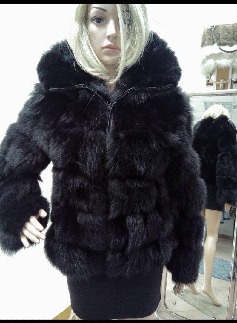 May include: A black faux fur jacket with a zipper closure and a hood. The jacket has a quilted design and is made of soft, plush fur.