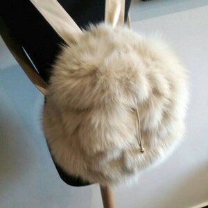 Puede incluir: Una mochila de piel sint&eacute;tica blanca con cierre de cord&oacute;n y correas de cuero.