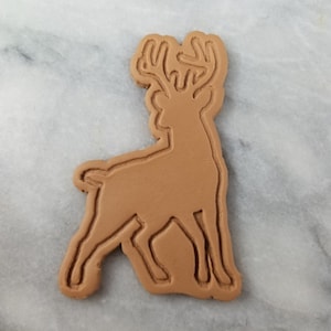 May include: A brown cookie cutter in the shape of a deer with antlers.