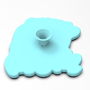 May include: A light blue silicone mold shaped like a cloud with a small, round, light blue indentation in the center.