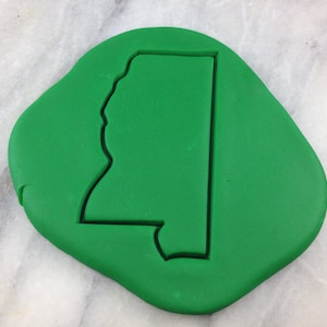 May include: A green cookie cutter in the shape of the state of Mississippi.