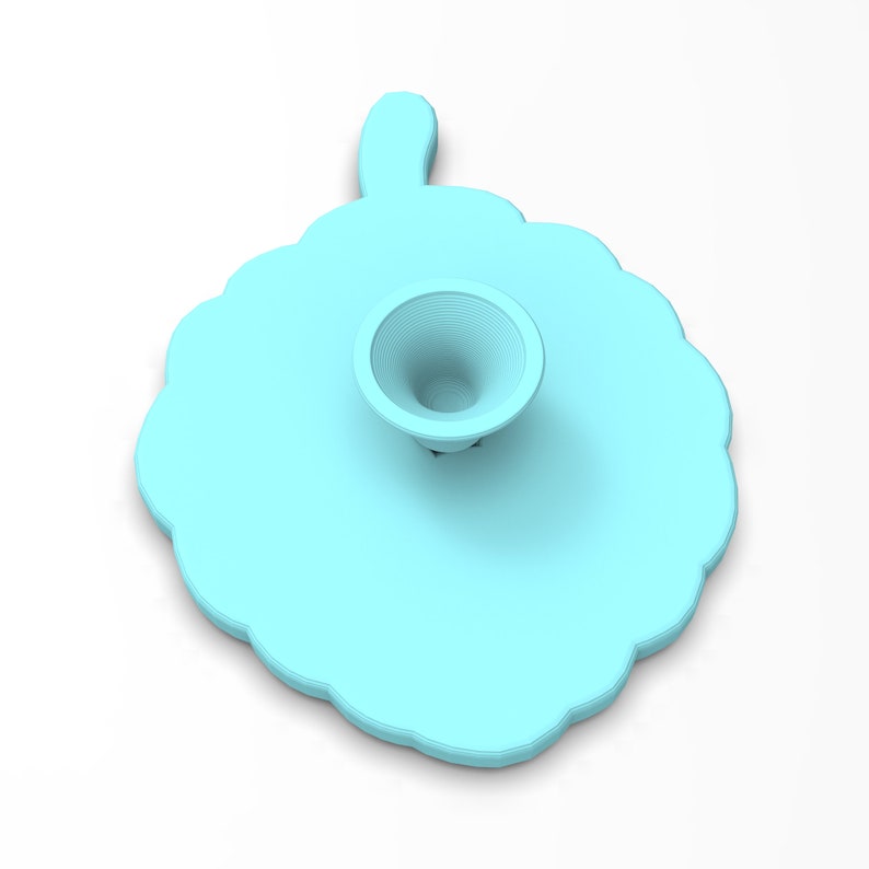May include: A light blue silicone phone stand with a scalloped edge and a raised center. The stand has a small, round, indented area in the center.