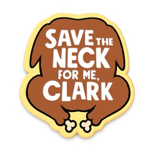May include: A yellow and brown cookie shaped like a turkey with the text "SAVE THE NECK FOR ME, CLARK" in white.