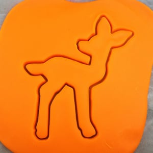 Könnte beinhalten: Orangener Plätzchenausstecher aus Kunststoff in Form eines Rehs. Das Reh steht mit dem Kopf zur Seite gedreht.