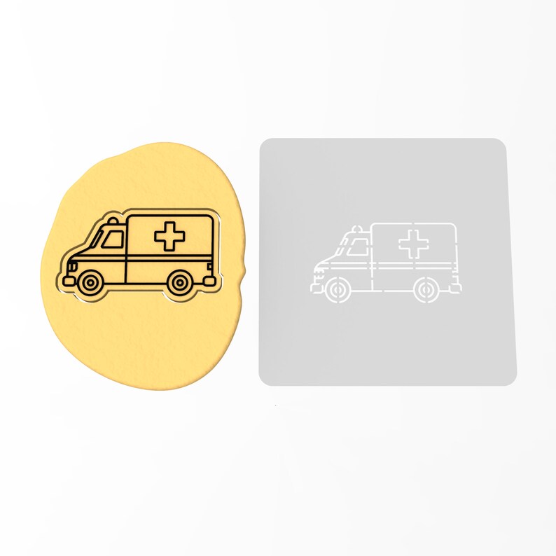 May include: A yellow cookie dough with a black outline of an ambulance with a red cross on the side. A gray stencil of the same ambulance is shown next to the cookie dough.