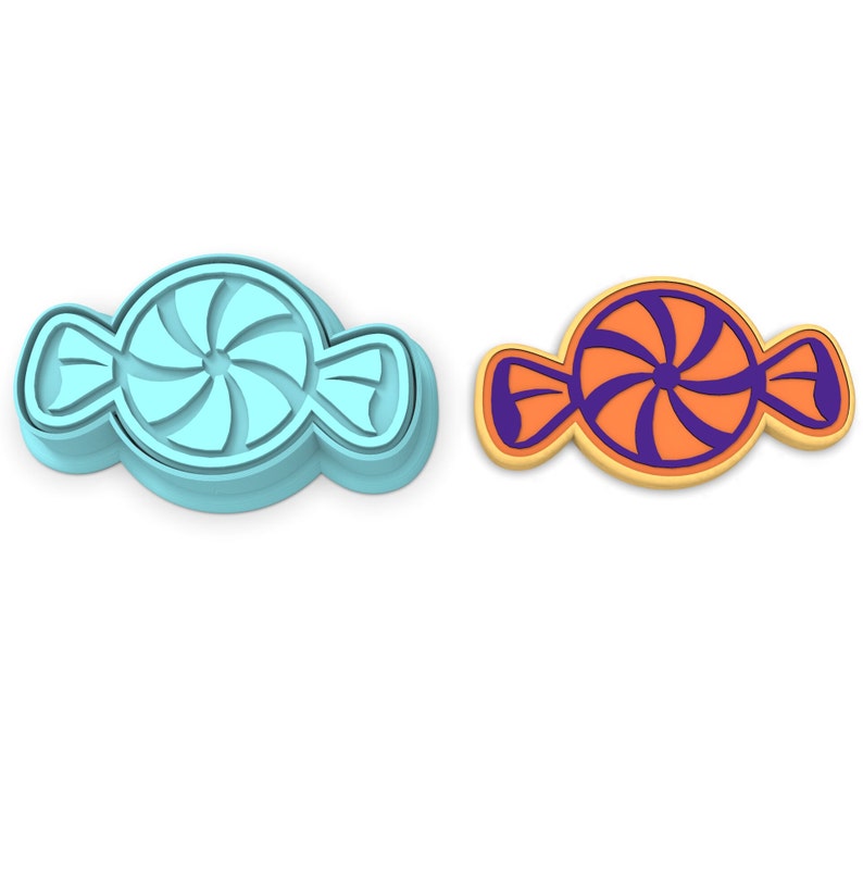 Puede incluir: Un cortador de galletas de pl&aacute;stico azul con forma de caramelo con un dise&ntilde;o de espiral. Junto a &eacute;l hay una galleta con la forma del cortador, con un contorno naranja y un dise&ntilde;o de espiral morado.