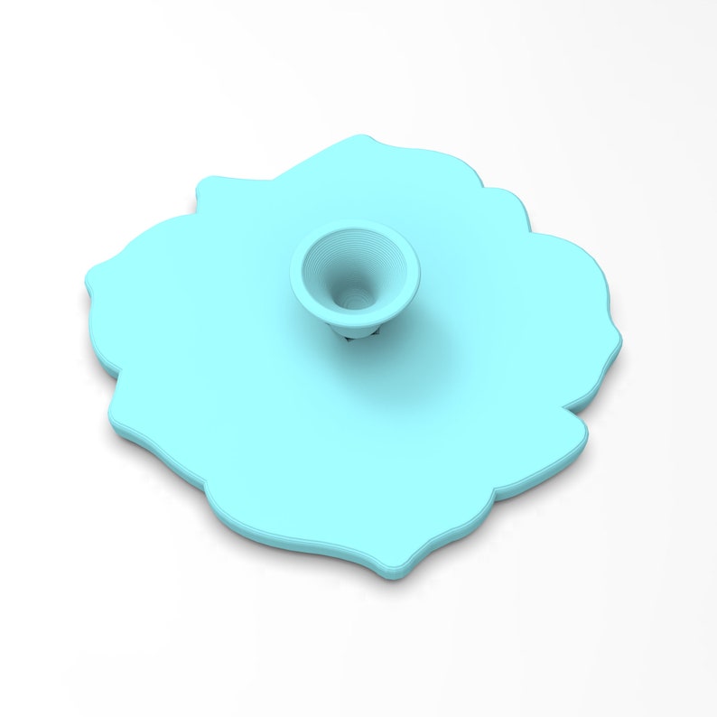 May include: A light blue silicone phone stand shaped like a flower with a raised center. The stand has a smooth, matte finish.