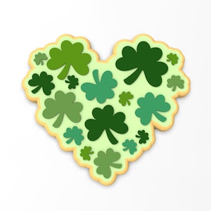 May include: A heart-shaped cookie decorated with green shamrock designs. The cookie is ideal for St. Patrick's Day.