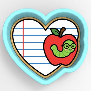 May include: A heart-shaped cookie cutter with a school theme. The design features a red apple with a green worm wearing glasses, set against a lined paper background. The cutter is outlined in brown and set in a light blue frame.