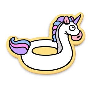Puede incluir: Un flotador de piscina inflable de unicornio amarillo con una melena y cola rosa y morada.