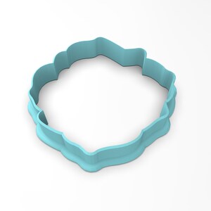 May include: A light blue plastic cookie cutter shaped like a flower with a scalloped edge.