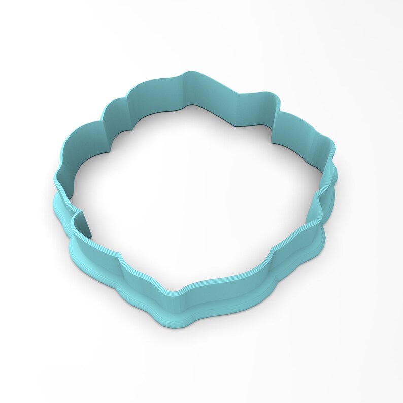 May include: A light blue plastic cookie cutter shaped like a flower with a scalloped edge.