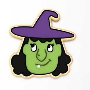 Puede incluir: Una galleta con temática de Halloween con forma de cara de bruja. La bruja tiene piel verde, pelo negro y un sombrero morado. La galleta está delineada en color marrón claro.