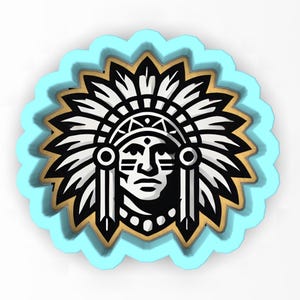 May include: A black and white Native American chief design with a feathered headdress, set against a gold and light blue scalloped border. The design features a detailed face and is likely a cookie cutter or craft item.