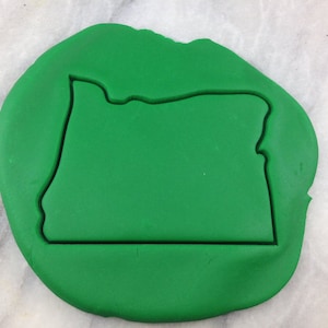 Puede incluir: Cortador de galletas verde en forma del estado de Oregón.