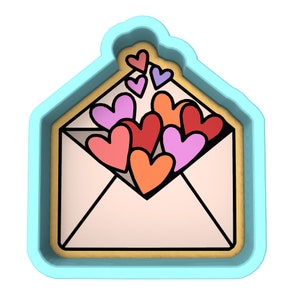 May include: A blue cookie cutter shaped like an envelope with a flap open and filled with red, pink, and orange hearts.