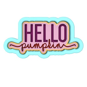Op de afbeelding: Een gelaagd ontwerp met de woorden "HELLO pumpkin" in een scriptlettertype. De tekst is in donkerpaars en lichtbruin, tegen een roze achtergrond, met een lichtblauwe omtrek.