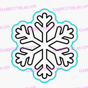 May include: A black and white snowflake cookie cutter with a scalloped edge. The cookie cutter is outlined in blue.