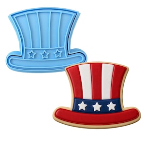May include: A light blue plastic top hat cookie cutter featuring vertical stripes and three stars on the brim, paired with a decorated cookie shaped like a top hat with red and white vertical stripes and a blue band with three white stars.
