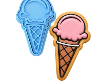 May include: A blue plastic ice cream cone cookie cutter next to a decorated ice cream cone cookie. The cookie has a pink scoop, a brown cone, and black outlines. The cookie cutter is a solid blue color.