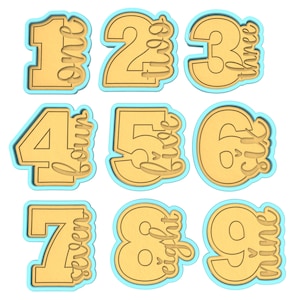 May include: Nine cookie cutters in the shape of numbers 1 through 9. Each cutter has a number and the word for the number written inside. The cutters are yellow and have a light blue outline.
