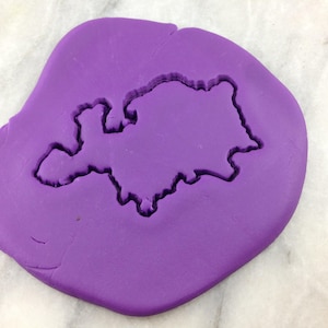 May include: Purple silicone baking mat with a cutout of a state shape.