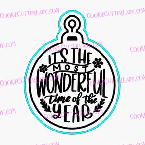 May include: Black and white cookie cutter in the shape of a Christmas ornament with the text "It's the most wonderful time of the year" inside.