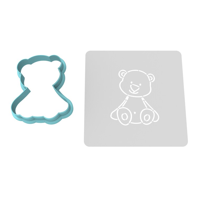 K&ouml;nnte beinhalten: Ein hellblauer Plastik-Ausstecher in Form eines Teddyb&auml;ren und eine graue Schablone mit einem wei&szlig;en Teddyb&auml;r-Motiv.