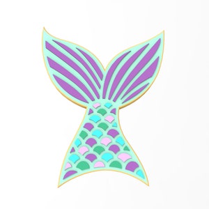 May include: A turquoise and purple mermaid tail with a gold outline. The tail is made of scales and has a fin on top.