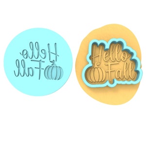 Op de afbeelding: Een blauwe koekjesuitsteker met de tekst "Hello Fall" en een pompoendesign.