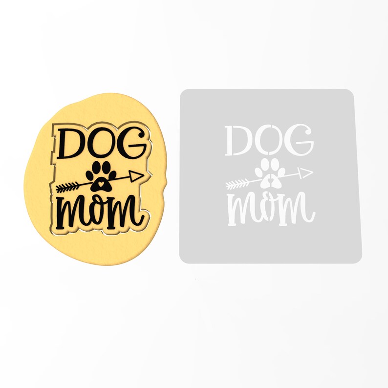 May include: A stencil for crafting, featuring the text "DOG mom" with a paw print and arrow design. The stencil is made of a white material and is shown on a light gray background.
