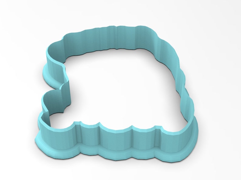 May include: A light blue plastic cookie cutter shaped like a cloud with a scalloped edge.