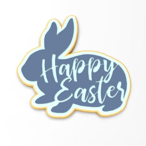 May include: A blue cookie cutter shaped like a bunny with the words "Happy Easter" inside. The cookie cutter is outlined in yellow.