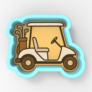 Könnte beinhalten: Ausstecher in Form eines Golfwagens mit hellblauer Umrandung. Der Wagen ist weiß mit braunen Rädern und einem beigefarbenen Innenraum. Auf der linken Seite des Wagens befindet sich eine Golftasche mit Schlägern.